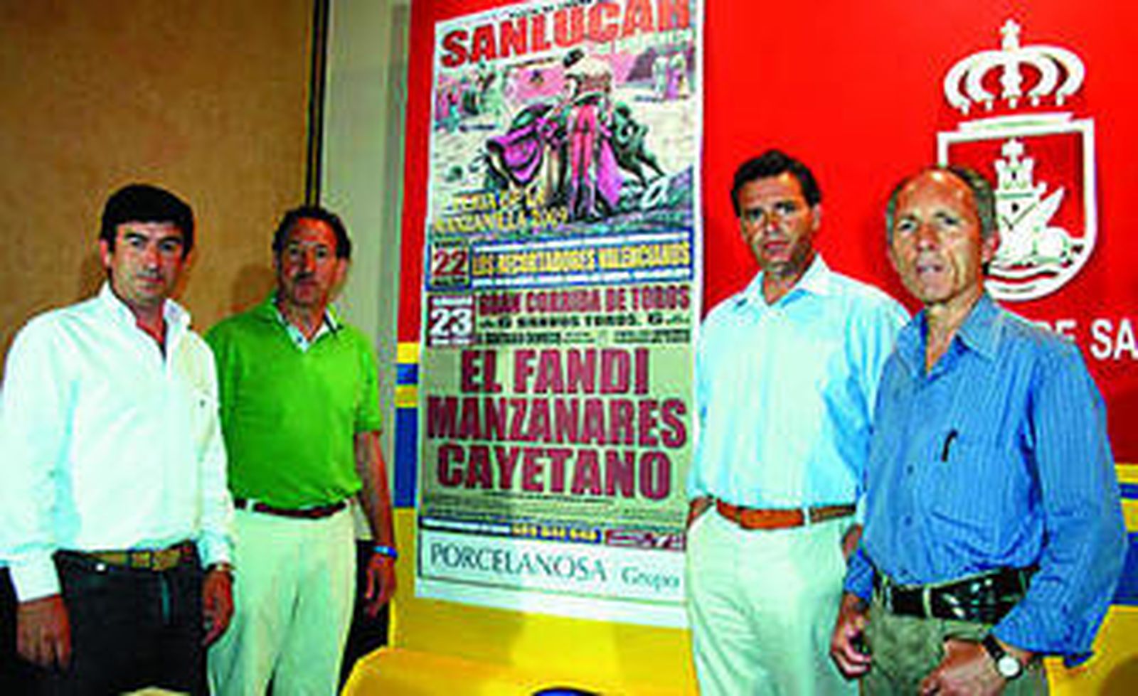 Los nuevos empresarios ante el cartel taurino de feria de la Manzanilla.