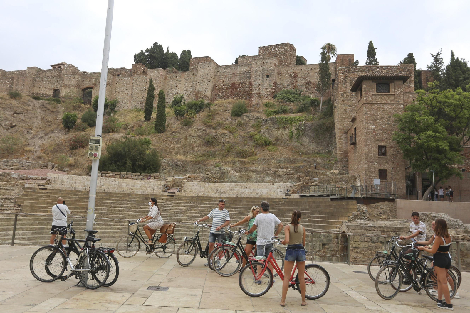Un grupo de turistas en la calle Alcazabilla, con las vistas del Teatro Romano y la Alcazaba.