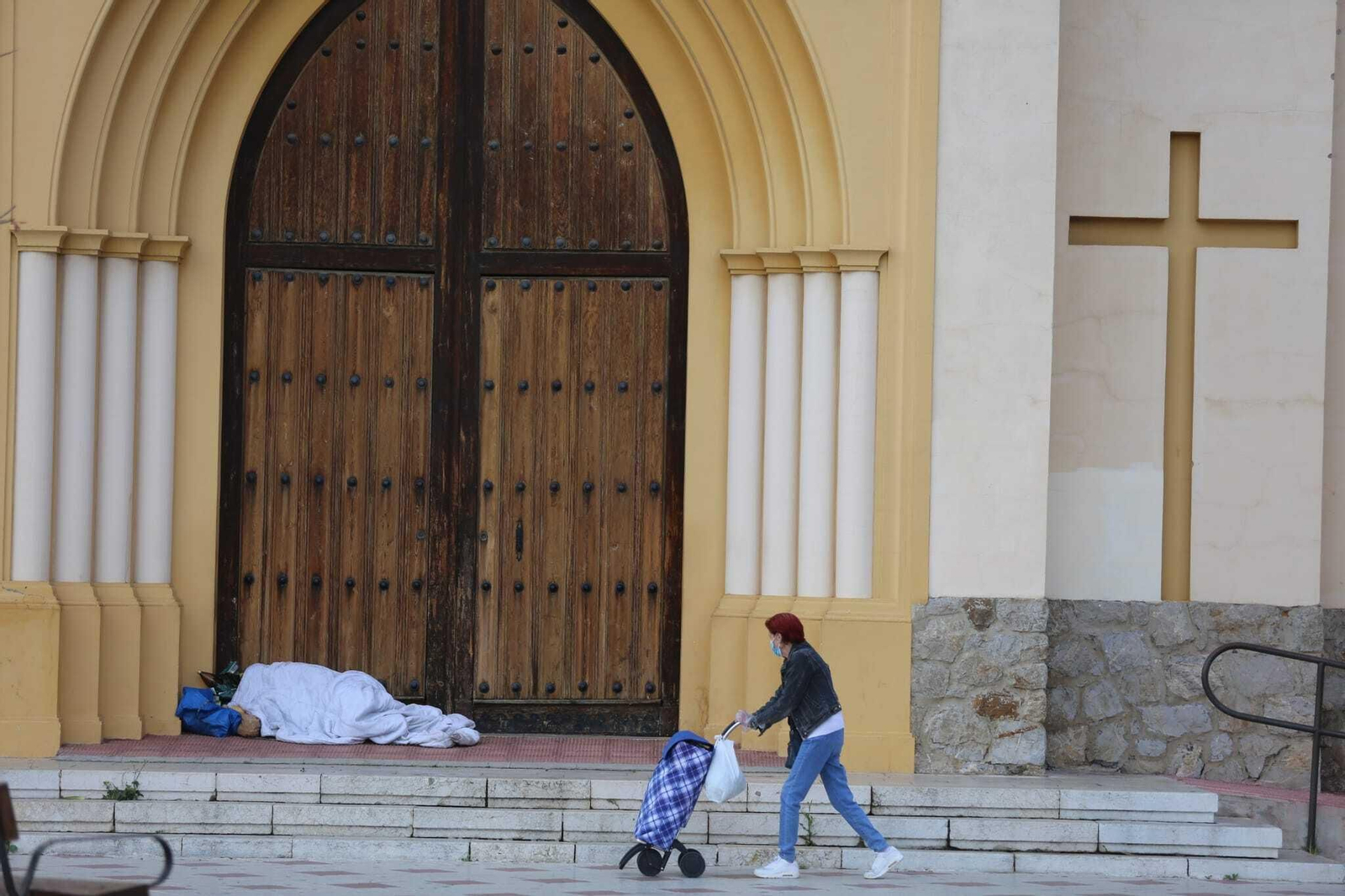 Una persona duerme en la puerta de la iglesia de San Patricio.
