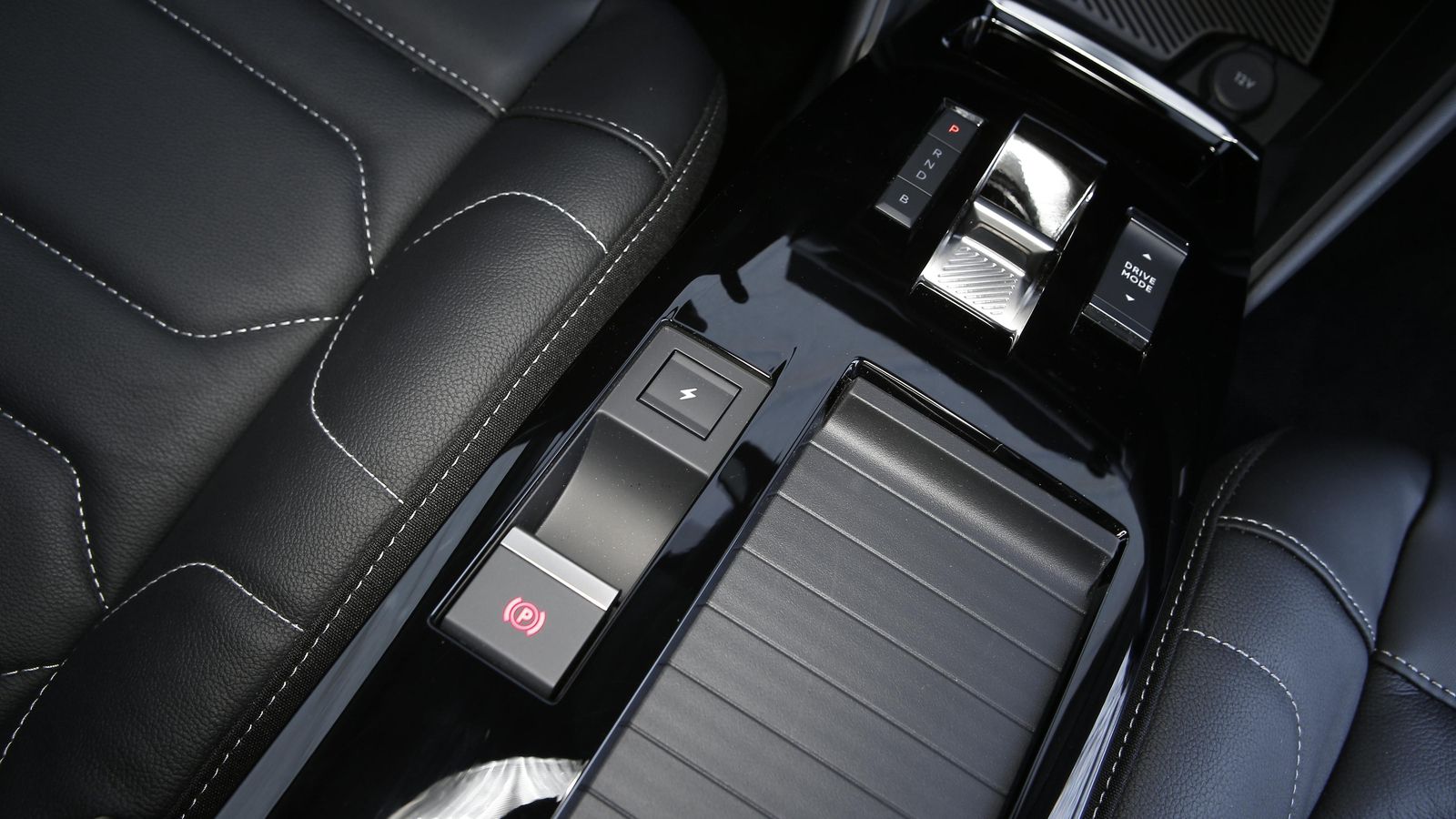 El control de la carga puede hacerse desde la pantalla central accediendo a la función correspondiente a través de este botón situado entre los dos asientos.