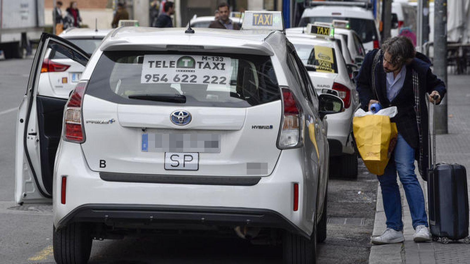 Una persona charla con un taxista la posibilidad de un servicio.