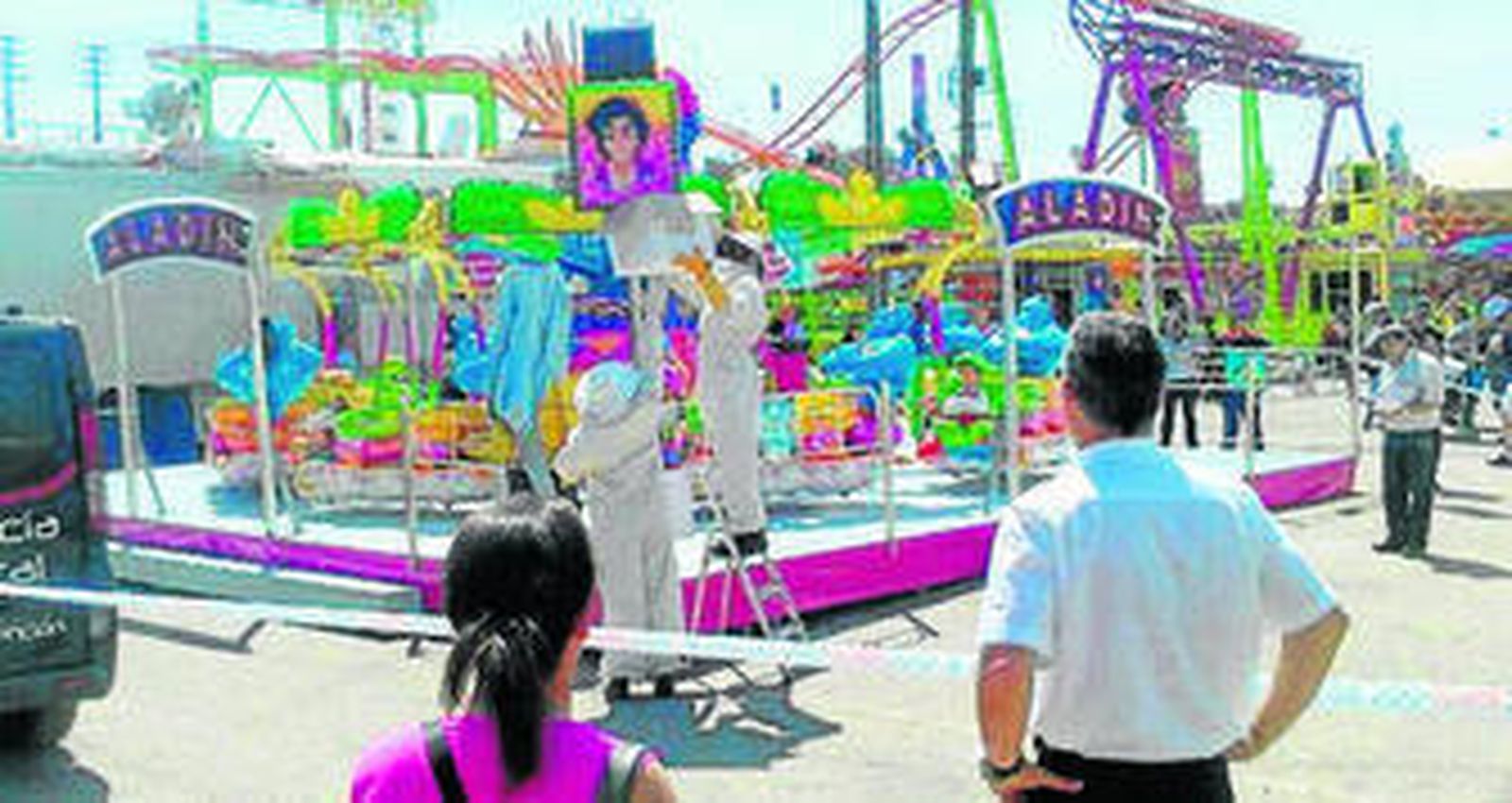 Operarios municipales quitan un panal de abejas cerca de una atracción.