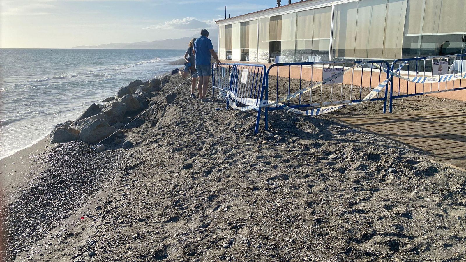 Dos personas cruzan la zona acordonada