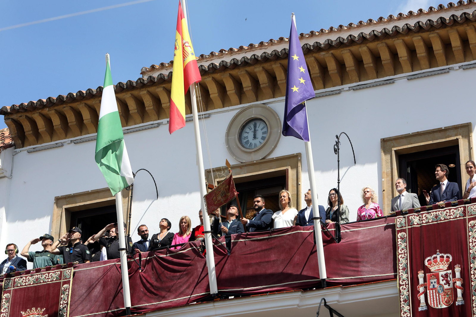La colocación del pendón en el balcón del Ayuntamiento.