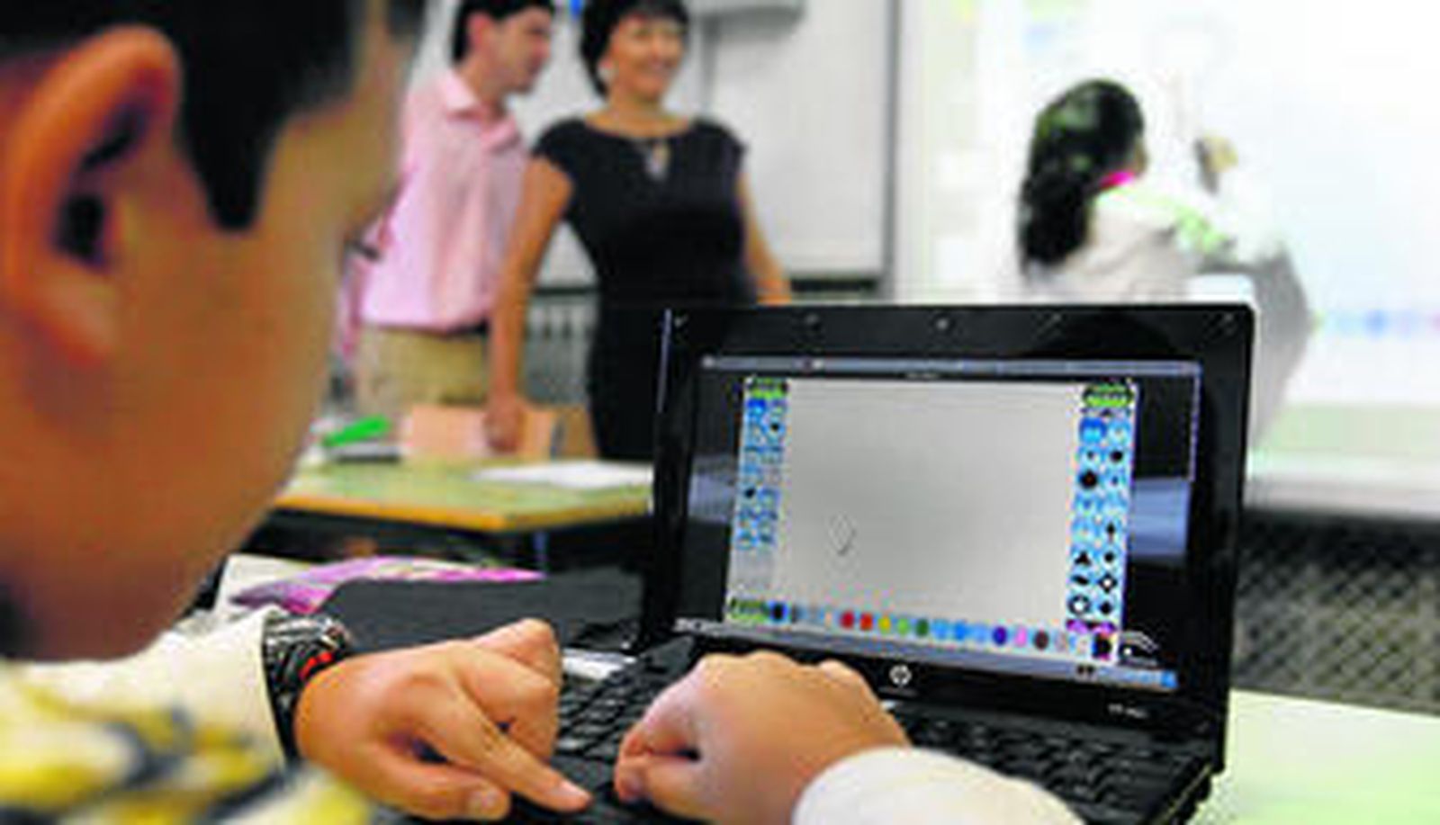Un alumno de 5º B del colegio Francisco de Quevedo, en Campanillas, maneja su portátil recién entregado por los delegados de la Junta.
