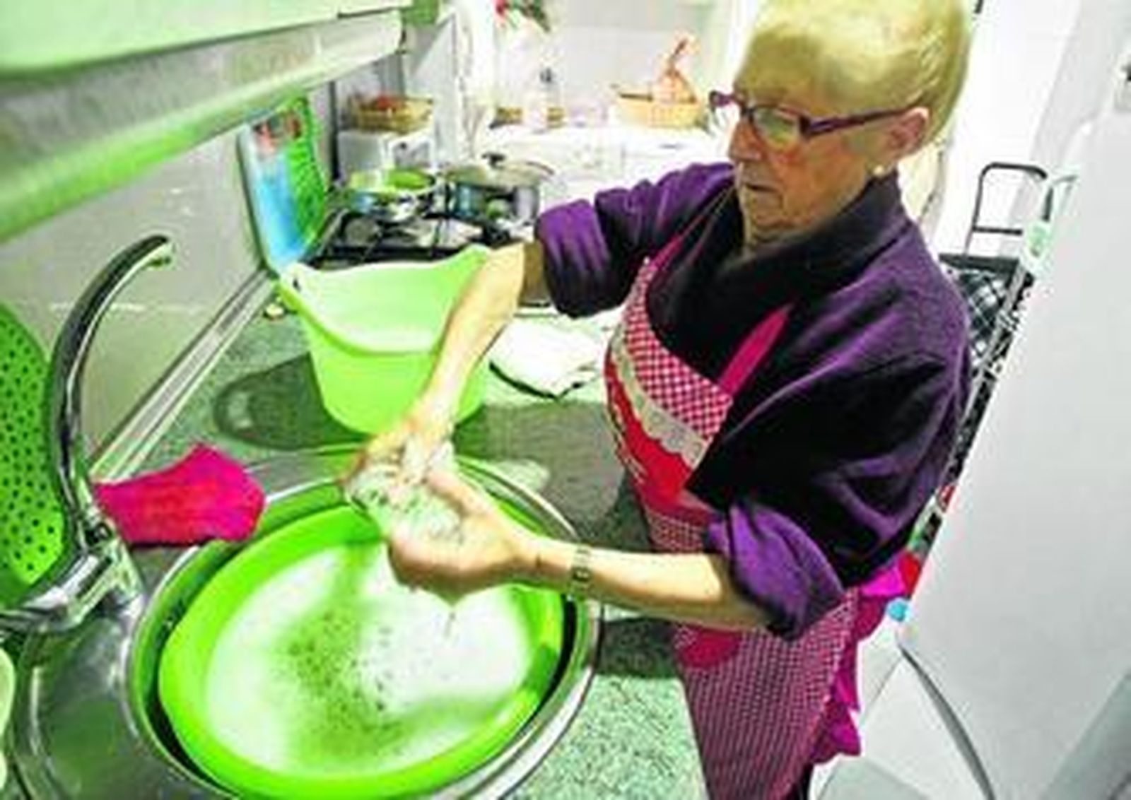 Una vecina de Loreto friega en un barreño al no disponer del suministro de agua potable.