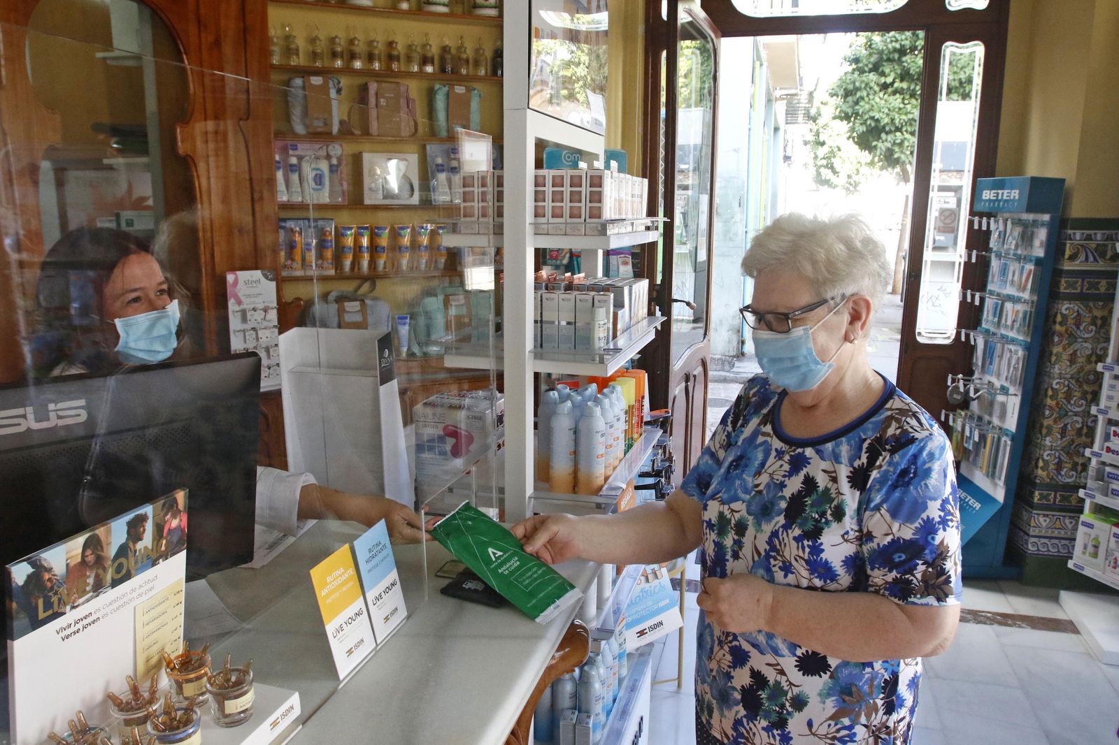 Una persona mayor recoge su mascarilla en una farmacia de Córdoba