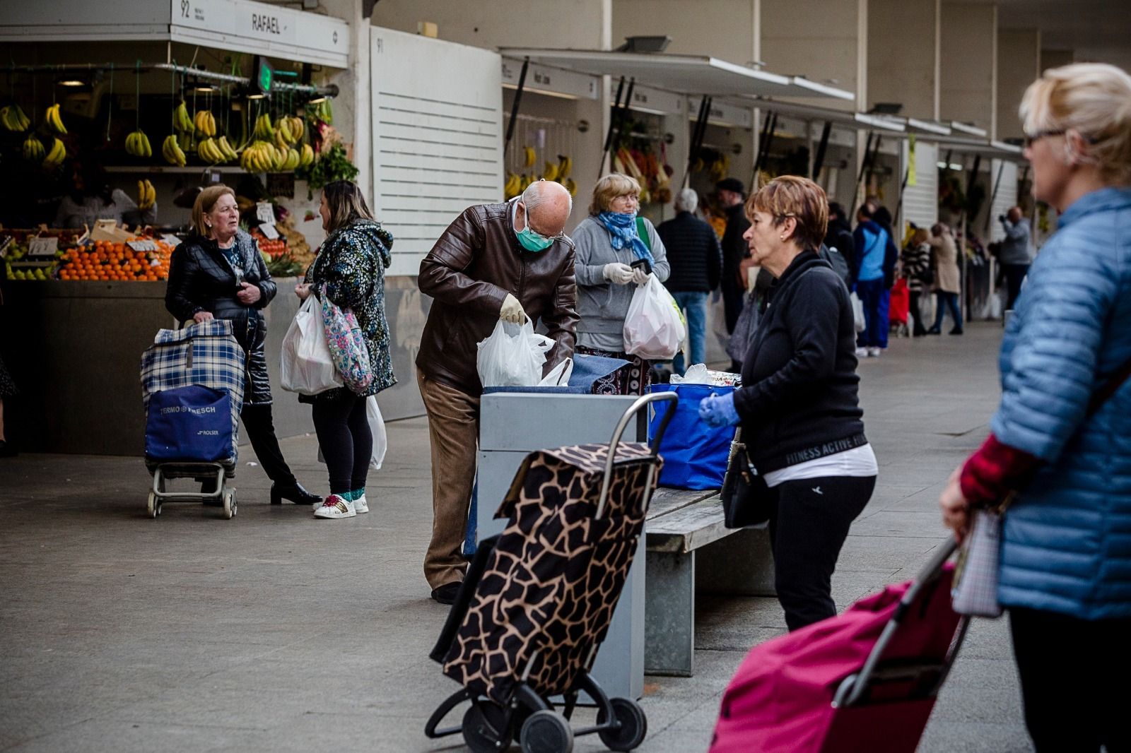 Varias personas transitan por el Mercado Central este sábado.