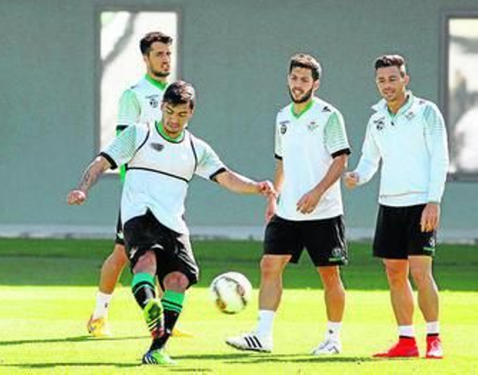 Reyes golpea el balón ante Dani Pacheco y Rubén Castro.