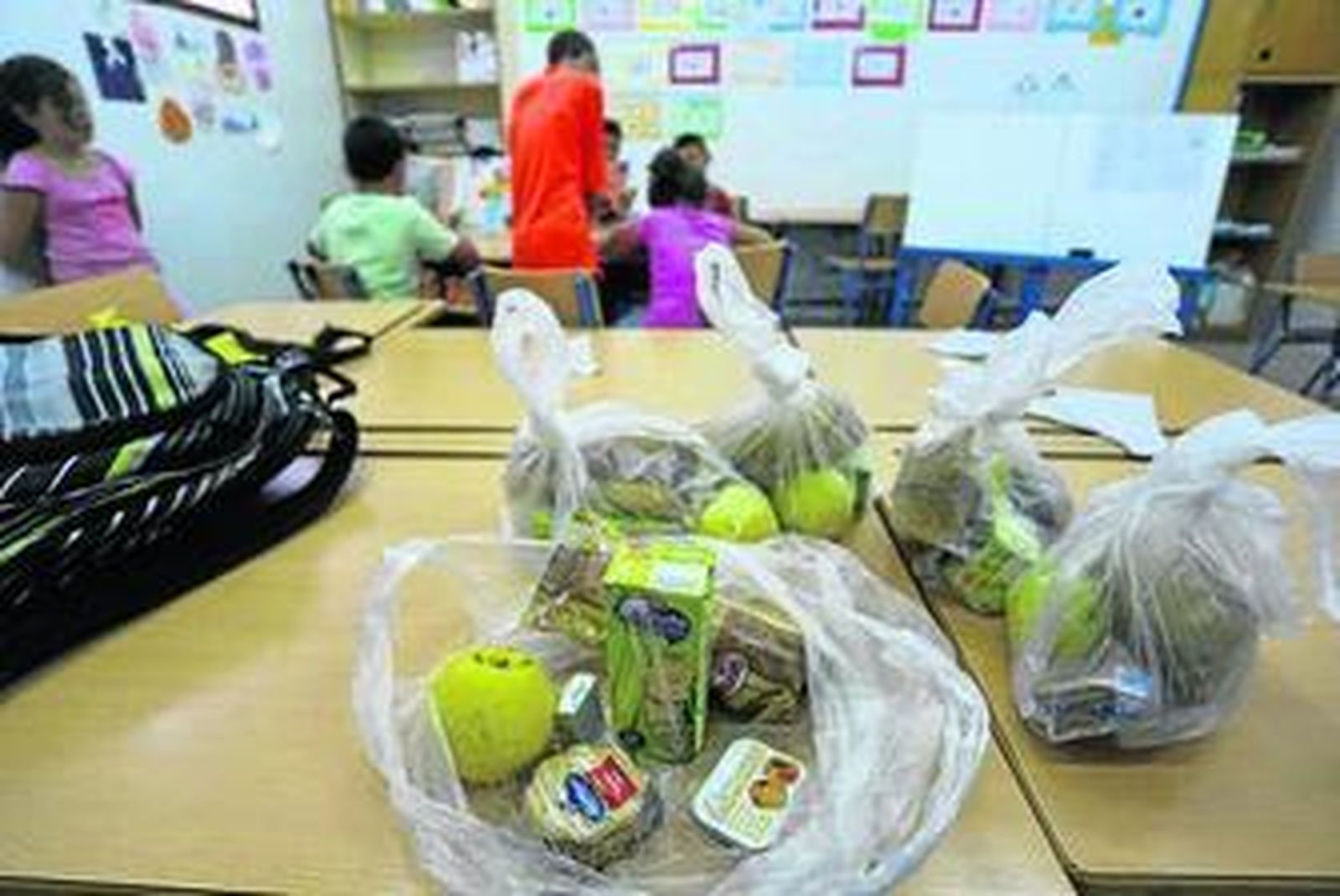 Bolsas con piezas de fruta, zumos y galletas dadas el curso pasado.