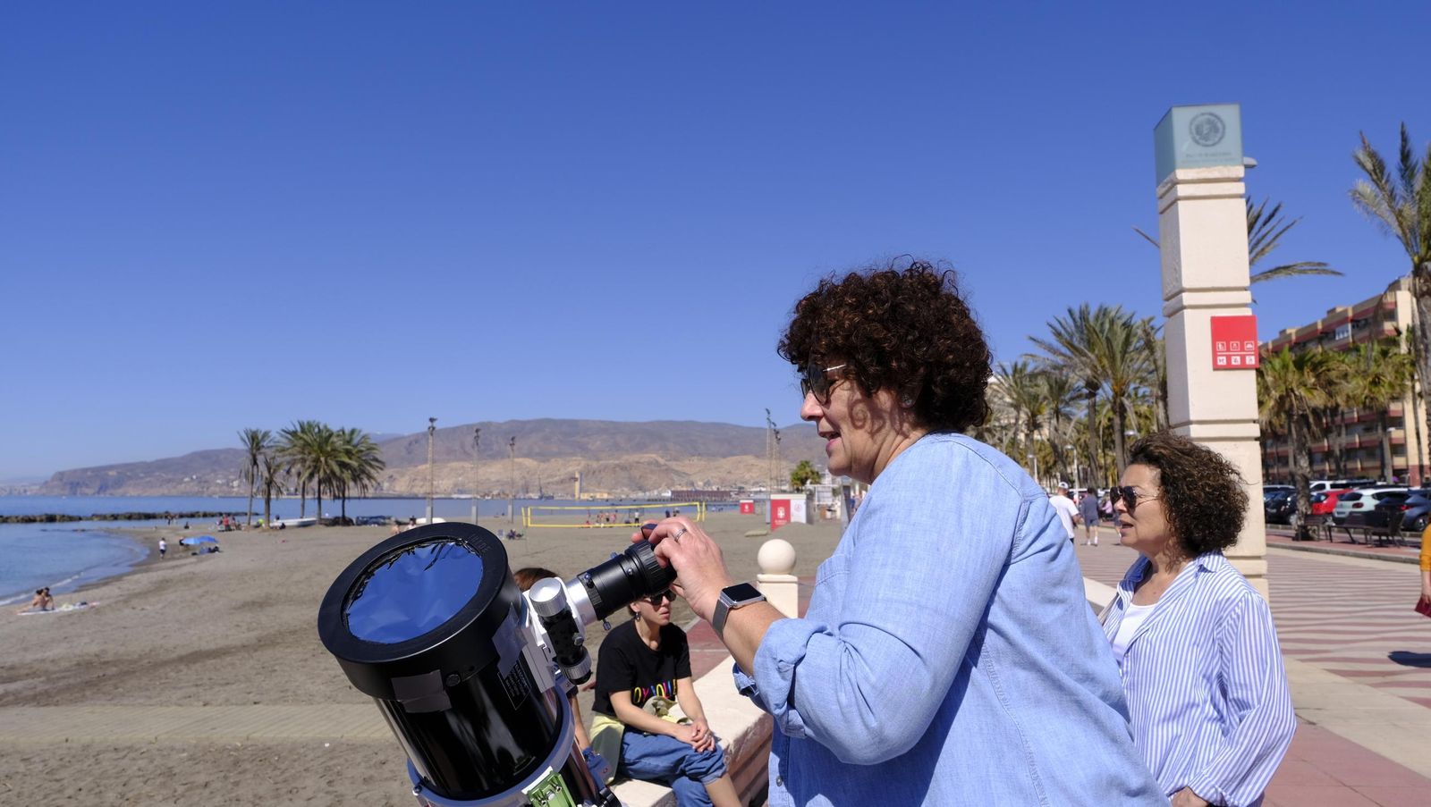 Almería observa el eclipse solar desde el Paseo Marítimo, en imágenes