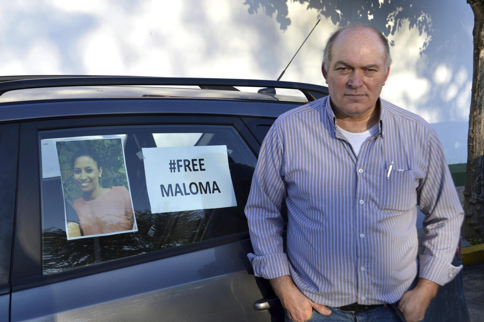 El padre de Malona, junto a una foto de la joven en su coche.