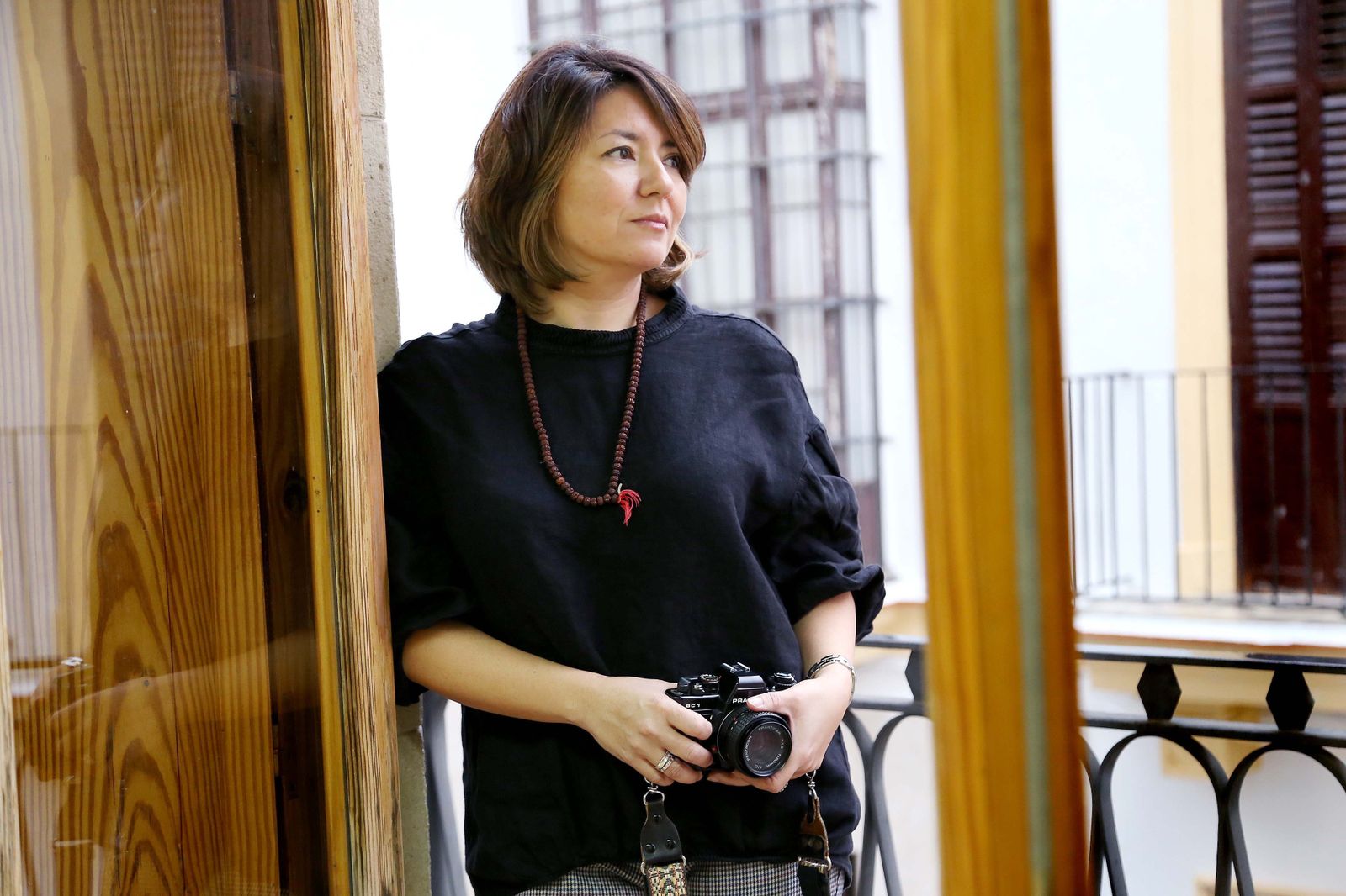 Arriba, la fotógrafa María Higuero, en una imagen tomada por Vanesa Lobo; a su lado, las manos del tonelero que parece bailar con la bota.