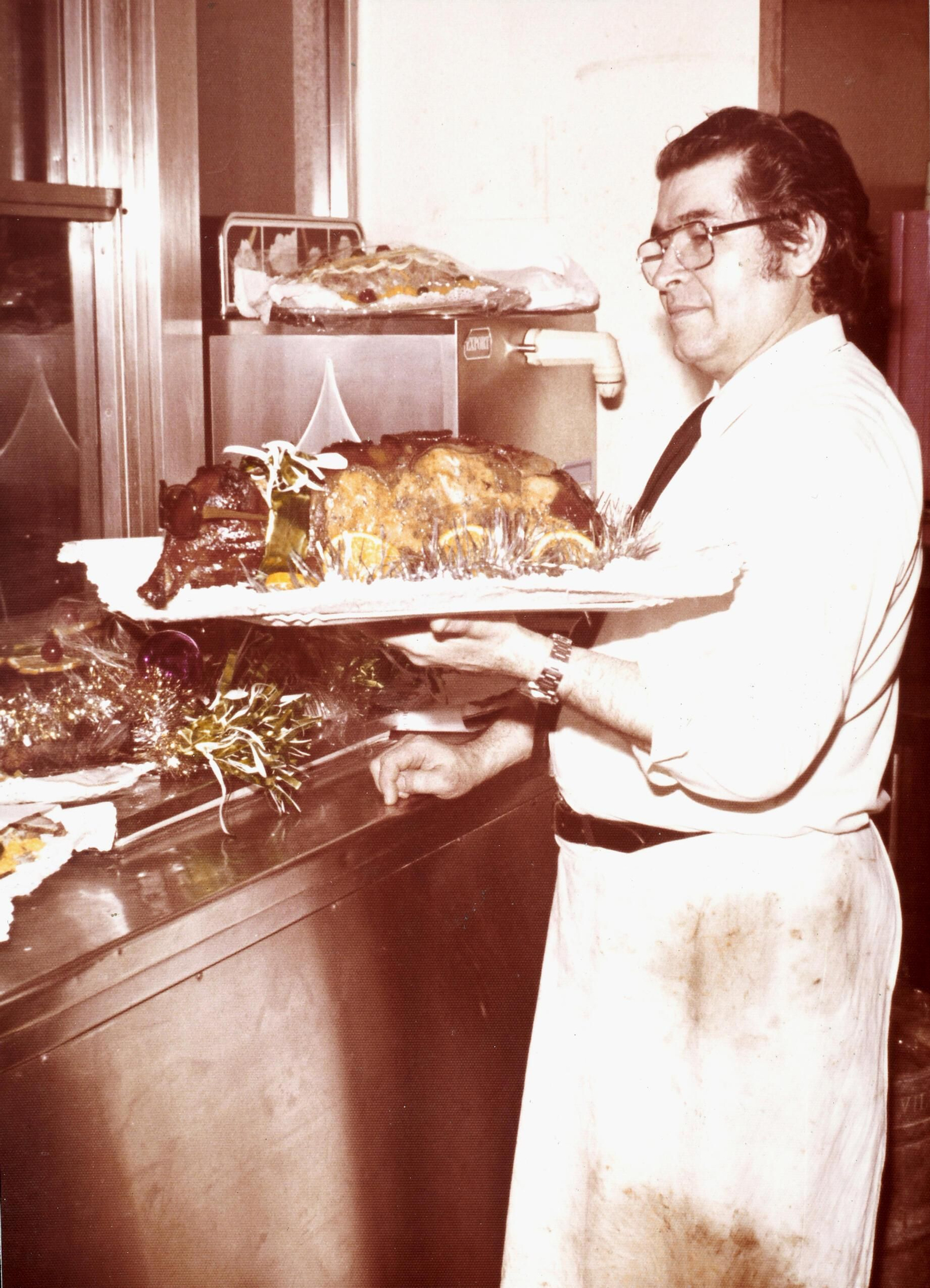 Emilio Sancho Mejías, con un cochinillo, listo para servir, una de las Navidades del siglo pasado.