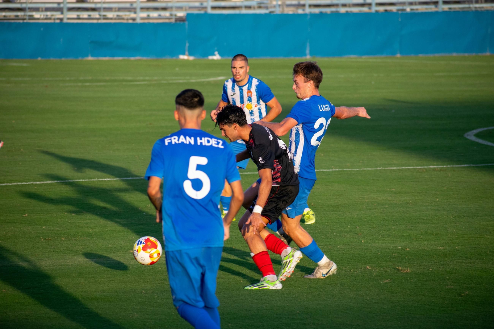 Un jugador del conjunto rojinegro intenta sortear la presión rival durante un encuentro a domicilio de esta temporada.