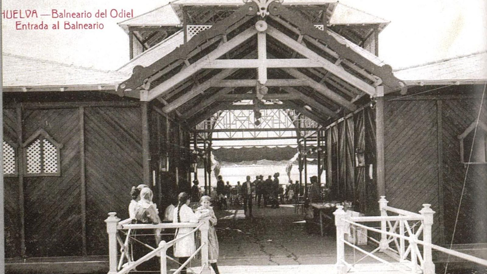 Entrada al balneario, con una pasarela de artística barandilla y hermoso artesonado en su techumbre de madera.