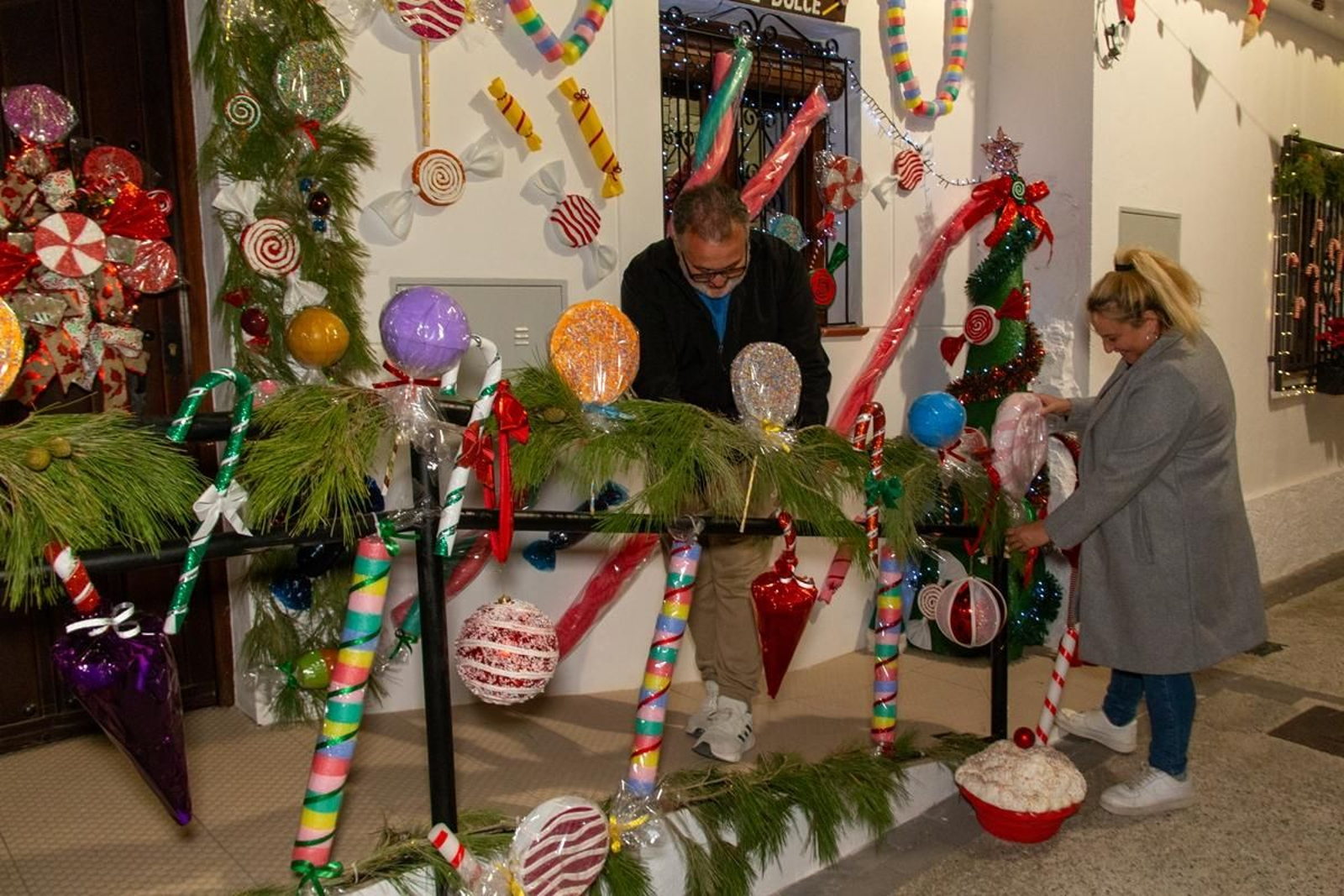 Dos vecinos colocando algunos de los dulces de su casa