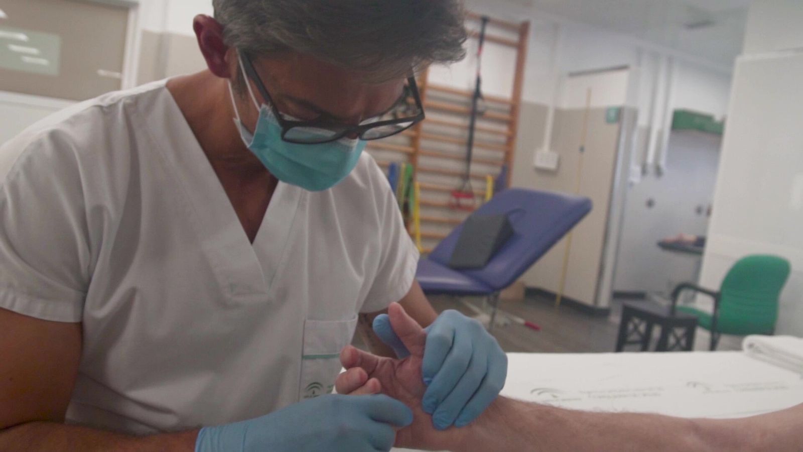 Un fisio atiende a un paciente en un hospital público.