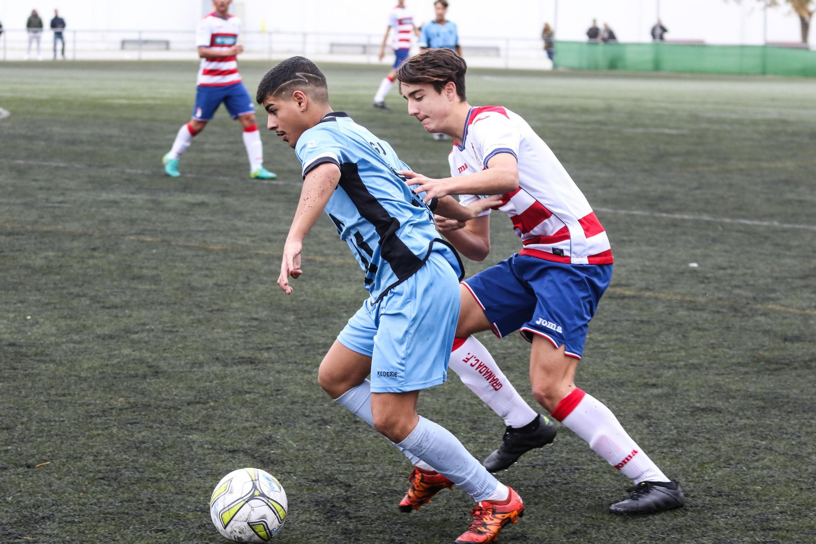 Un jugador del 26 de Febrero protege el balón ante la presión de un local.
