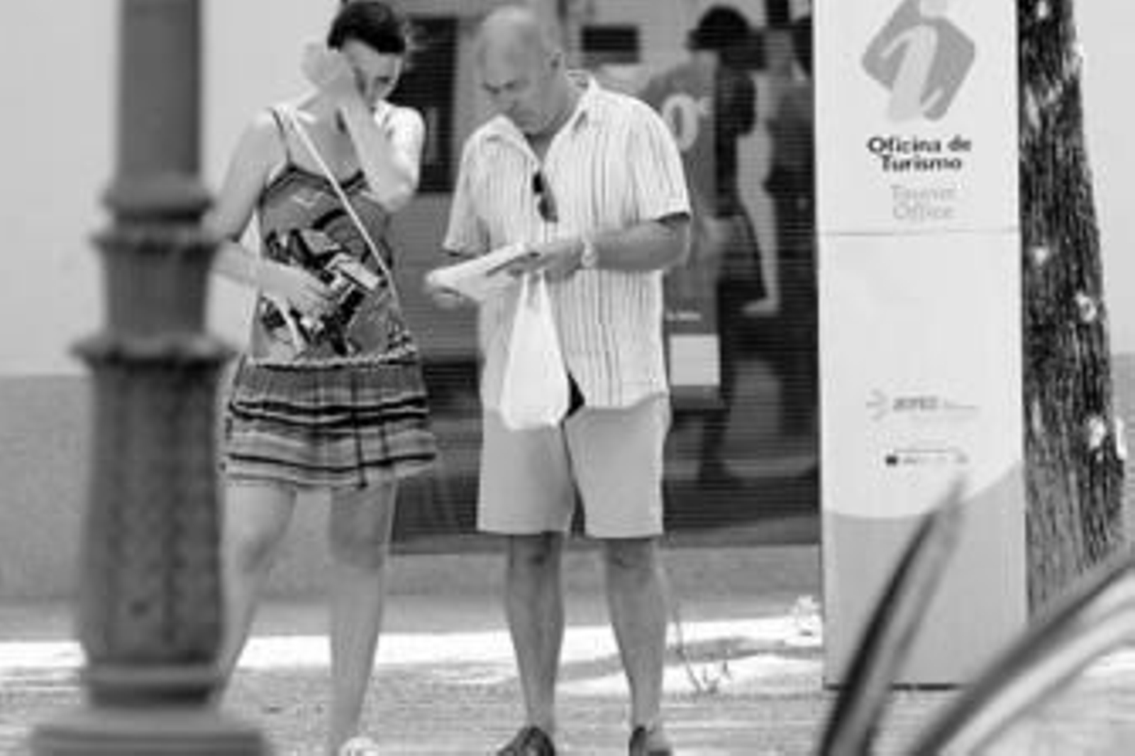 Unos turistas consultando ayer un plano de la ciudad bajo un sol de justicia.