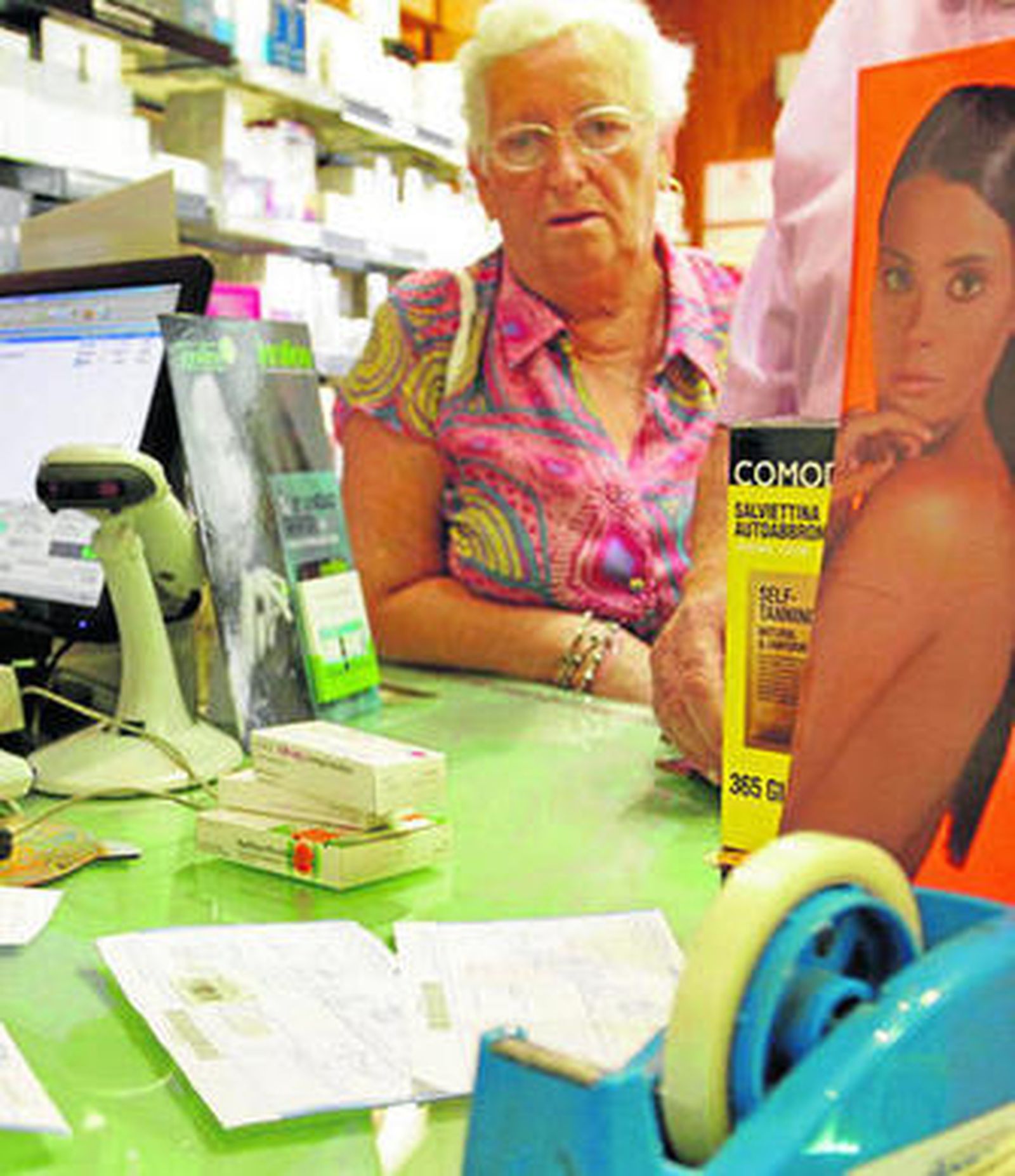 Un farmacéutico dispensa fármacos a una usuaria.