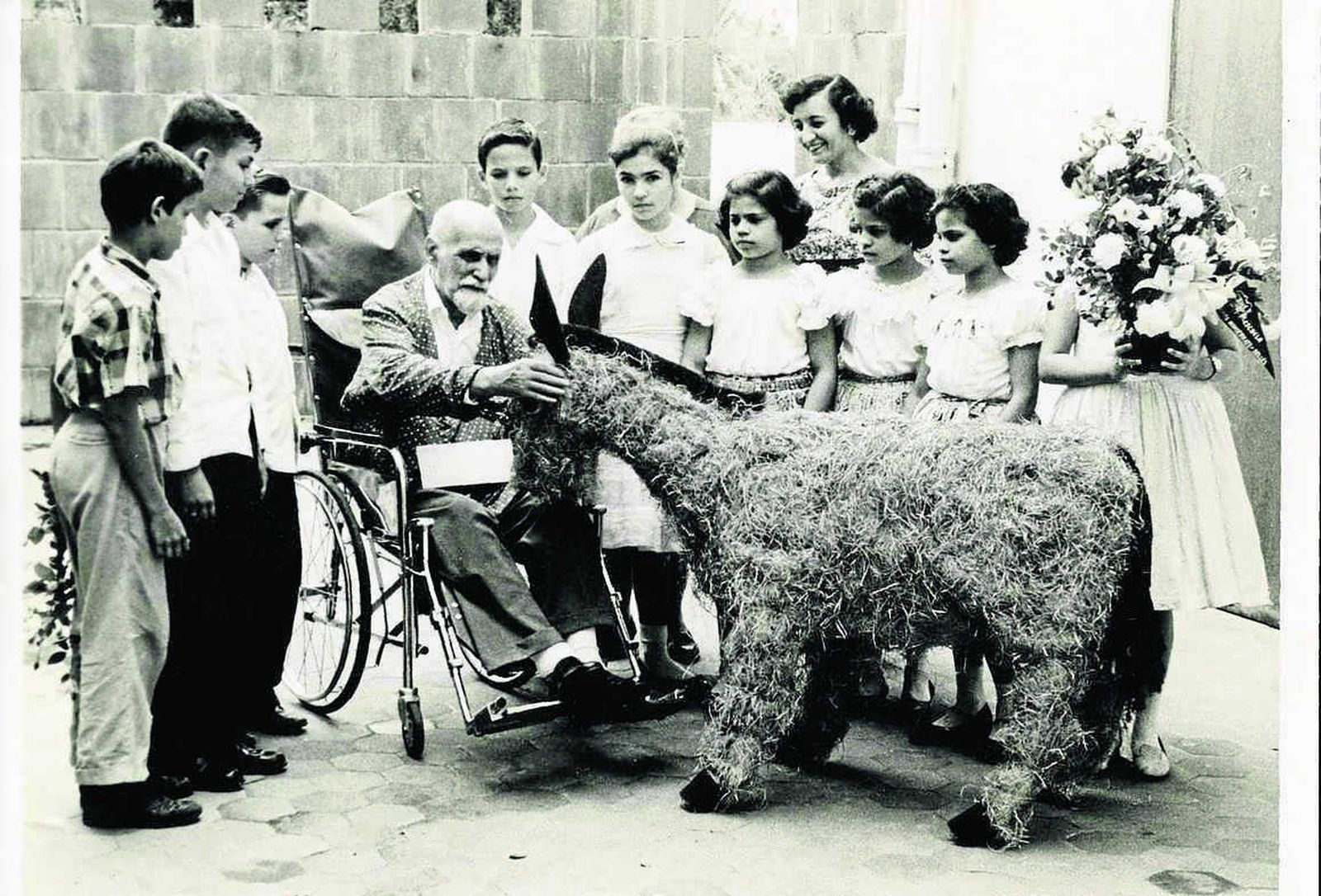El poeta recibe de un grupo de escolares en Puerto Rico una reproducción de Platero en paja y tela. Es la última fotografía del poeta con vida y está incluida en 'Historias'.