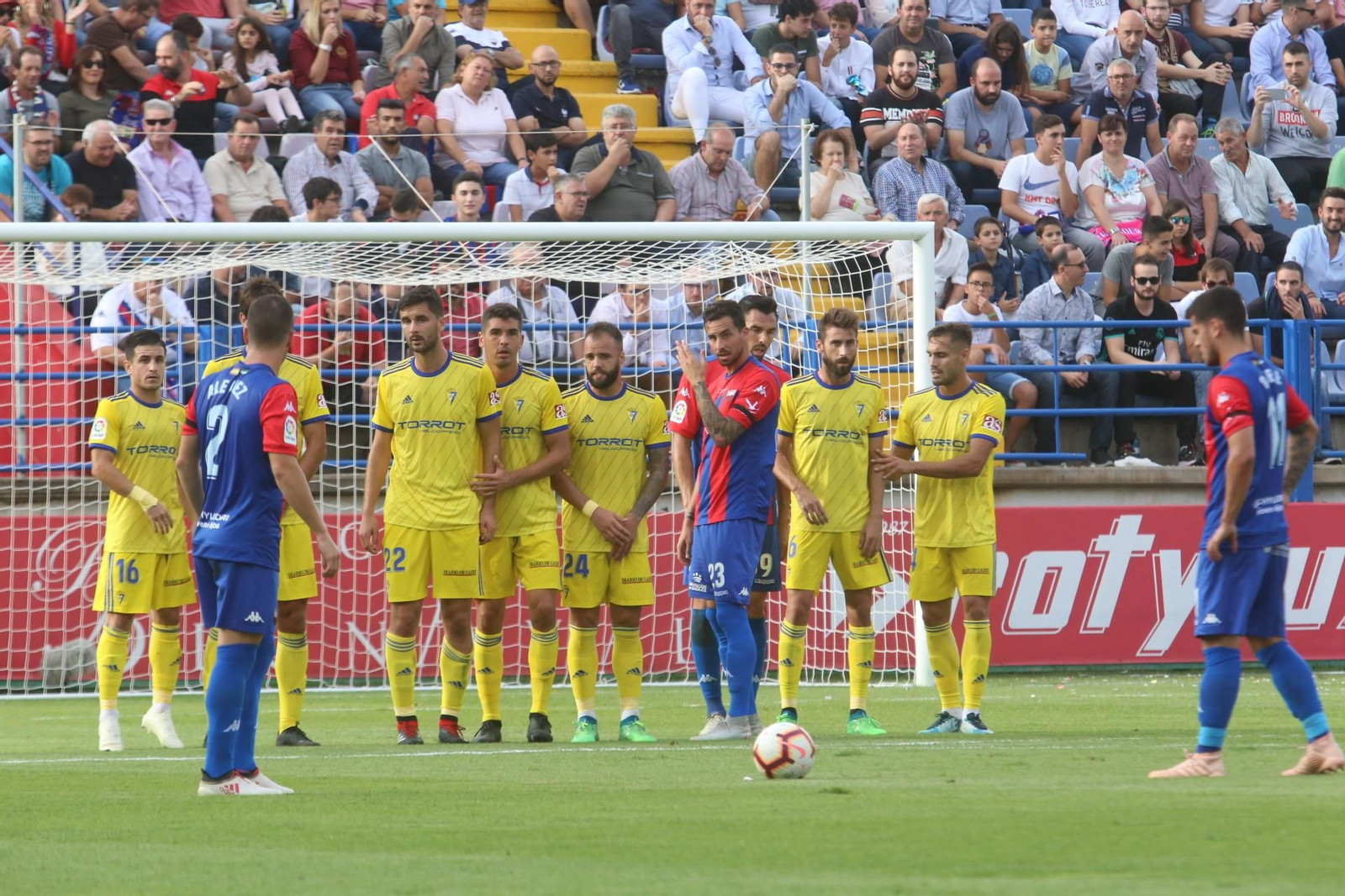Los jugadores del Extremadura se disponen a ejecutar una falta.