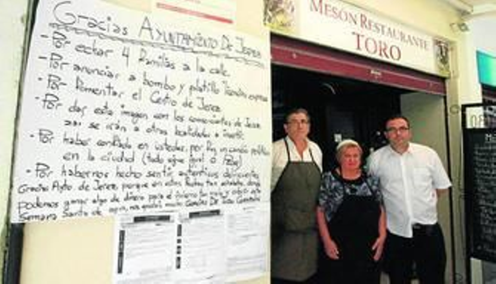 Francisco Toro, dueño del mesón Toro, en la puerta de su negocio, días atrás, junto a dos de sus empleados.