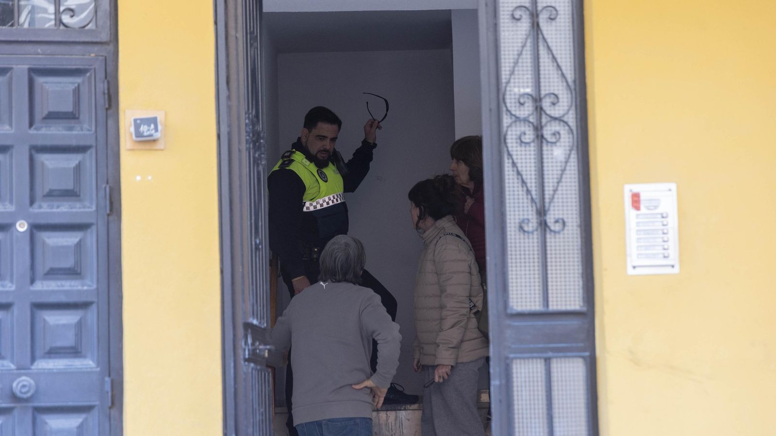Un policía local habla con unos vecinos.