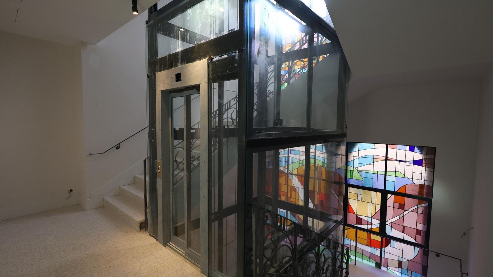 Ascensor, con la estructura original, y vidriera del Palacio de la Tinta.