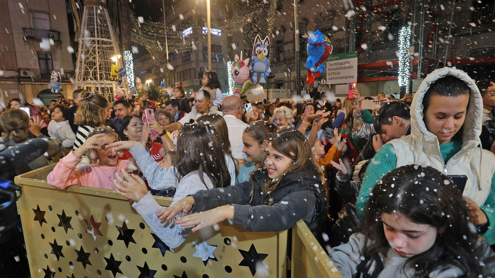 Niños disfrutando de la primera nevada de la Navidad en la ciudad.