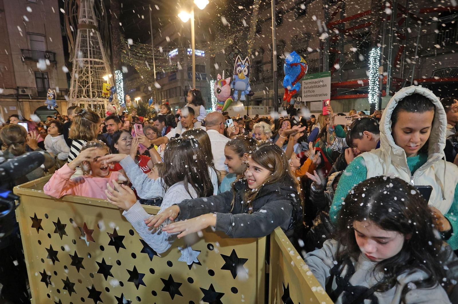 Niños disfrutando de la primera nevada de la Navidad en la ciudad.