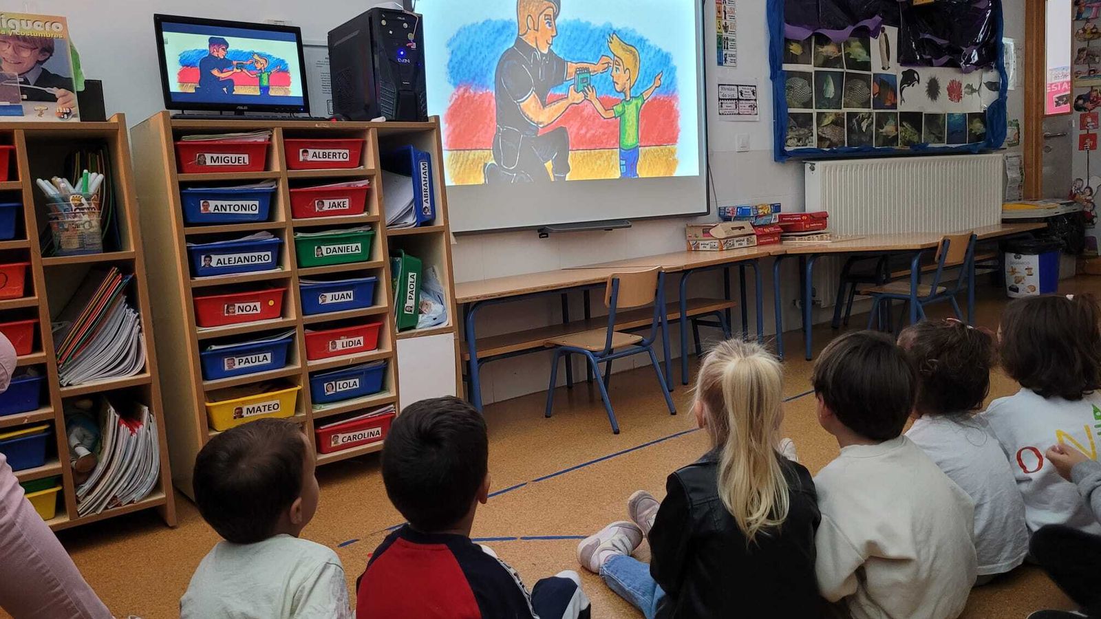 Los niños atienden las recomendaciones del cuento proyectado en una pantalla