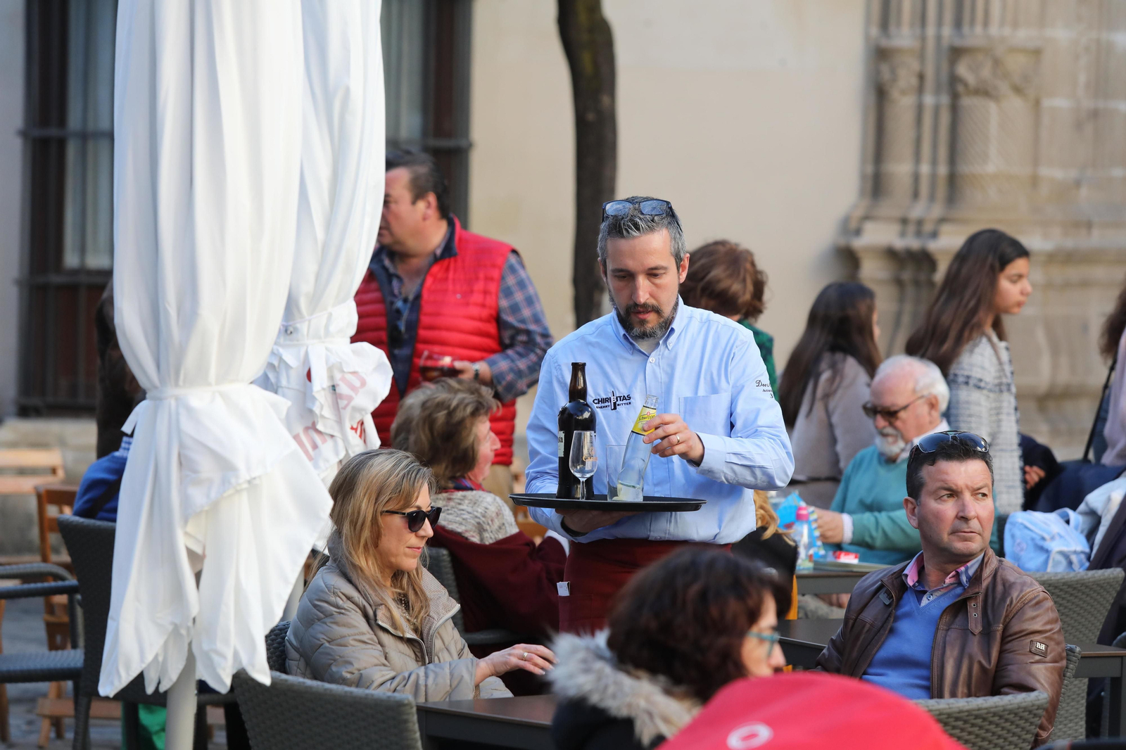 Un camarero atiende a una mesa de clientes en una terraza del centro de Jerez.