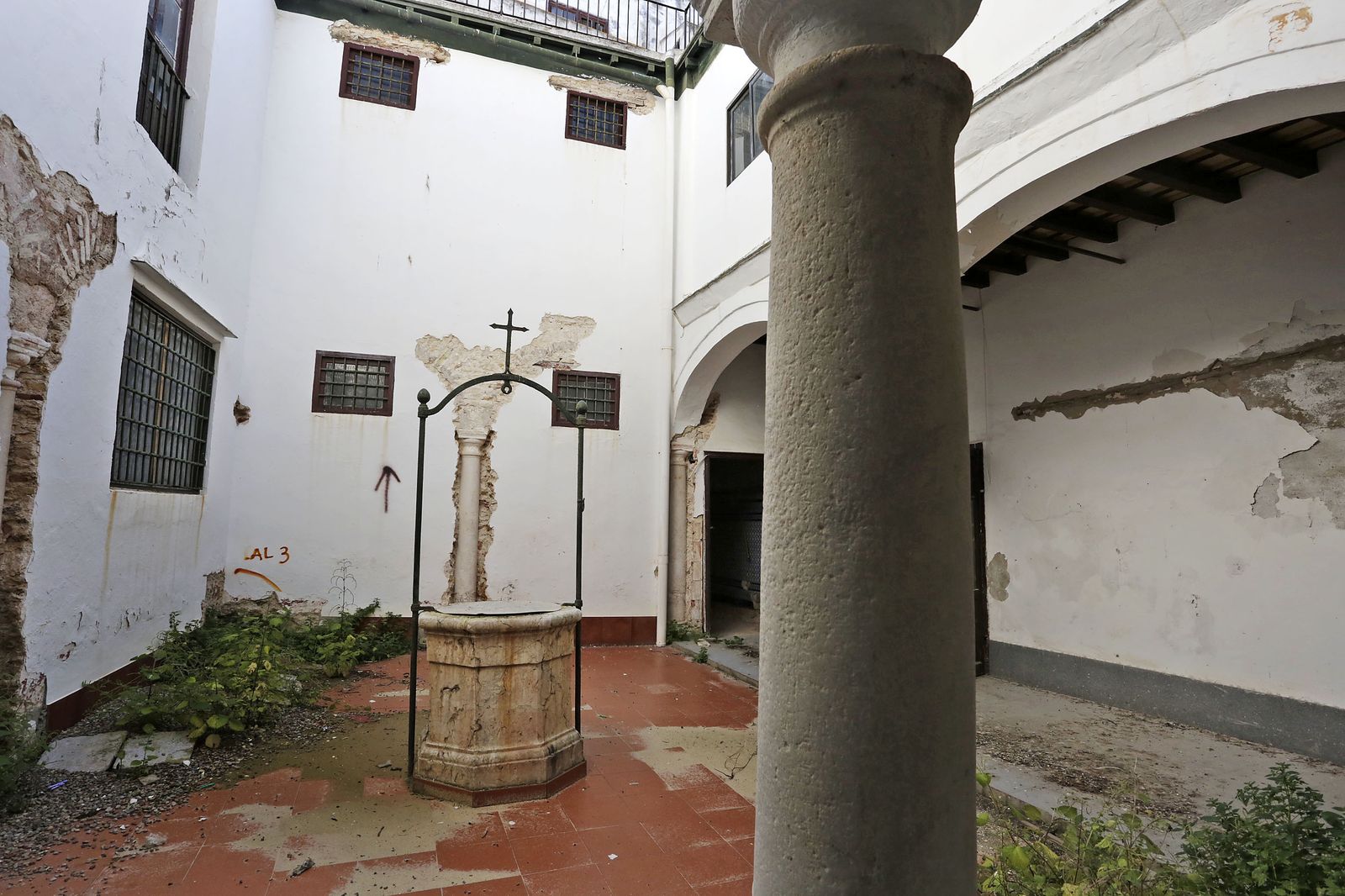 El aljibe que se encuentra en medio del patio, donde puede verse una de las catas que descubrió el resto de columnas del claustro menor.
