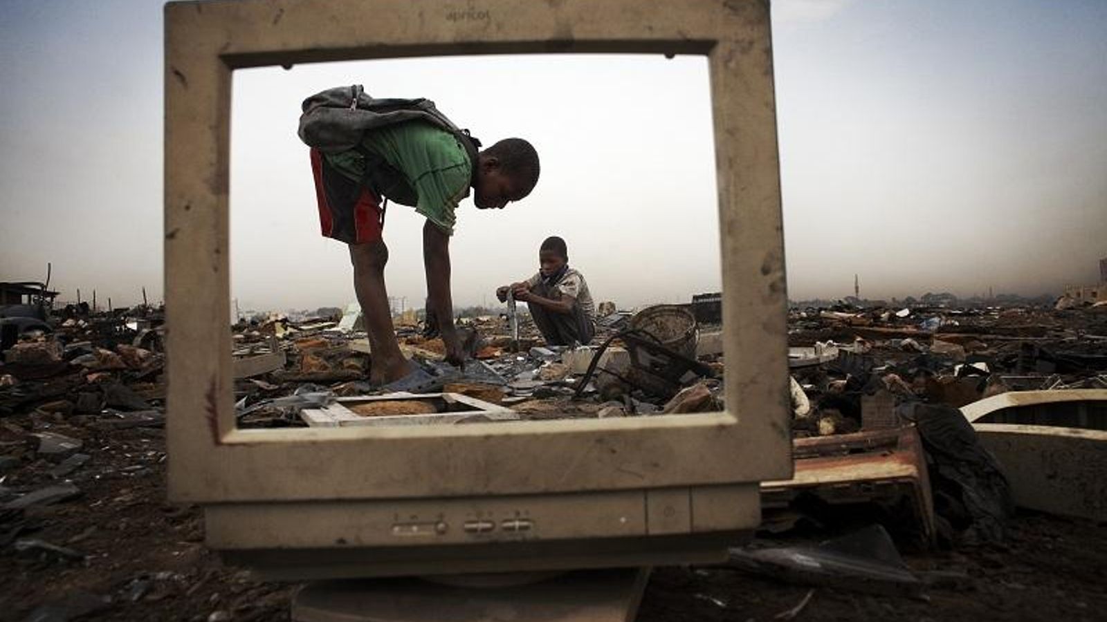 Un vertedero en el que se observa en primer plano la pantalla de un aparato tecnológico