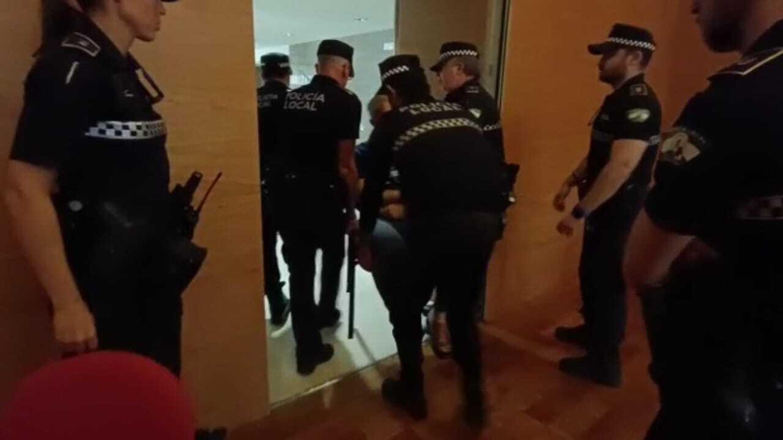 El sindicalista de policía local, desalojado del salón mientras permanecía en el asiento. El sindicalista de policía local, desalojado del salón mientras permanecía en el asiento.