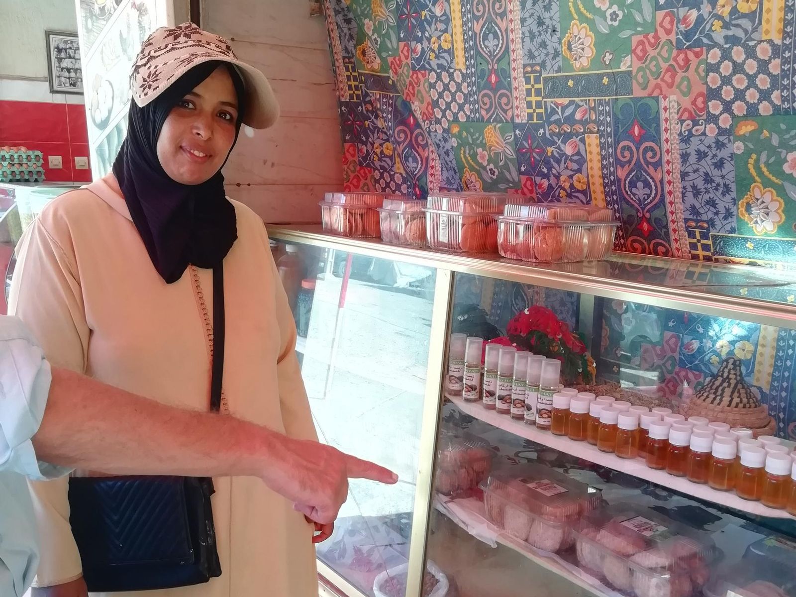 Una mujer junto a un expositor de dulces marroquíes.
