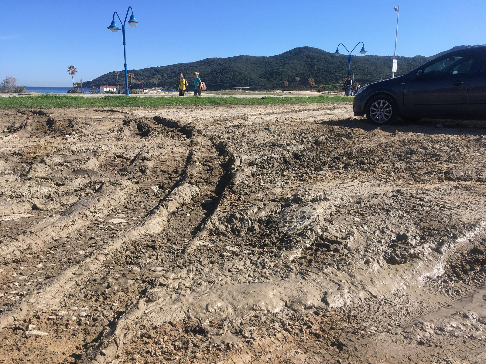 Aparcamiento lleno de barro y socavones al cabo de la calle Orión, en Getares.