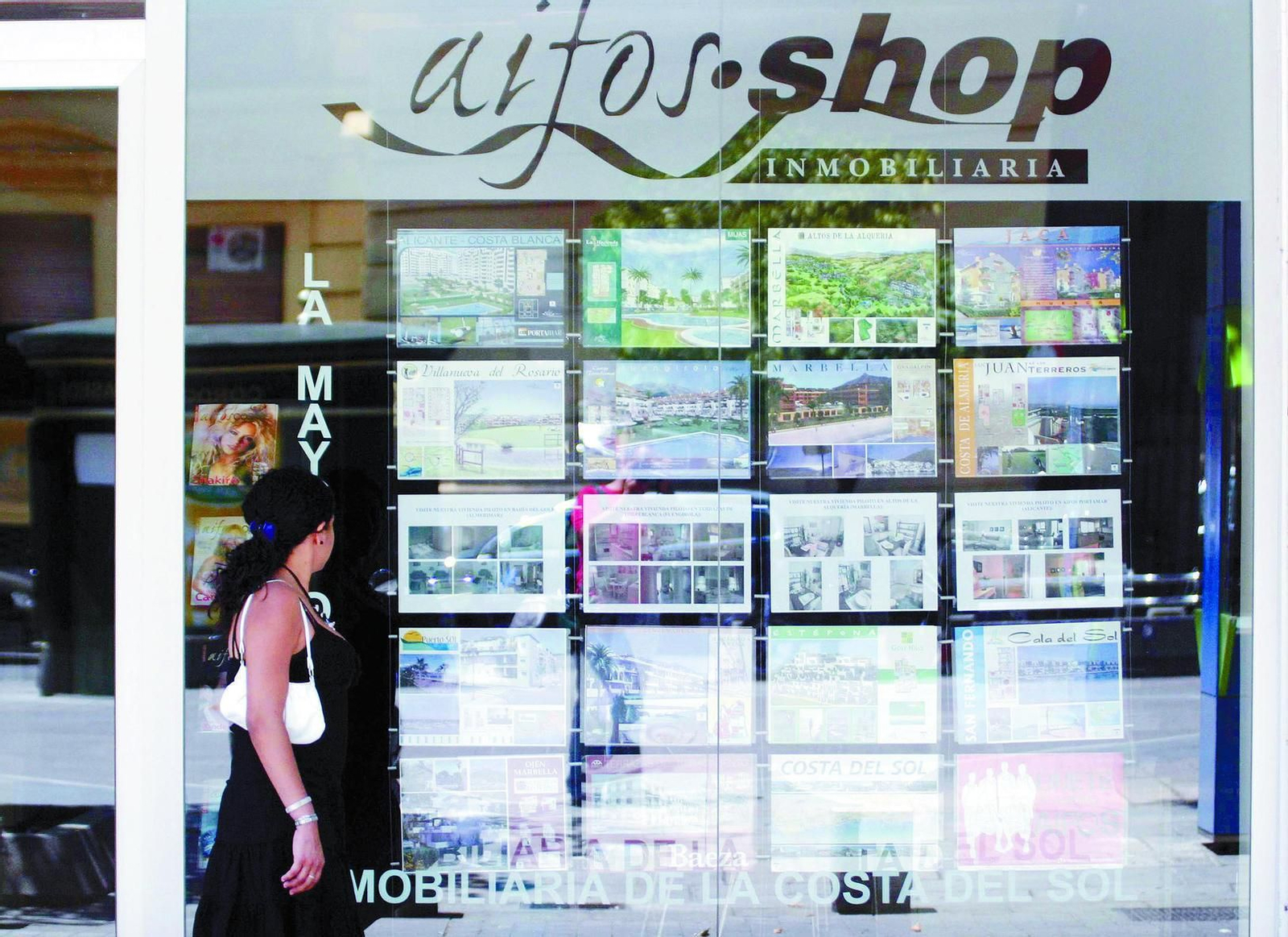 Una mujer pasa junto a una oficina de Aifos en 2006, cuando la empresa estaba operativa y vendiendo casas en media España.