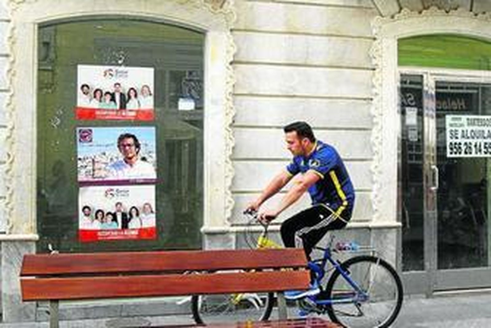 Carteles electorales en la fachada de un local vacío.
