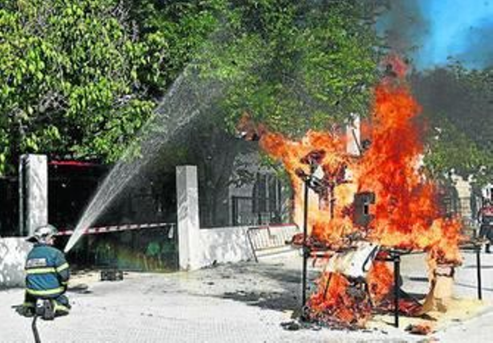 Un bombero apaga un 'juanillo' en una edición anterior de la fiesta.