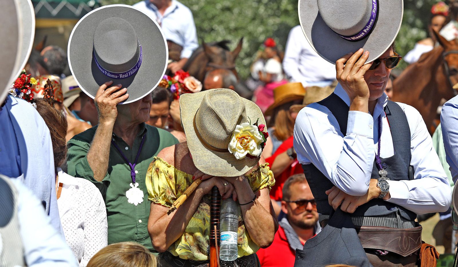 Rocieros jerezanos se cubren con el sombrero del sol durante la MIsa en Marismilla el pasado año.