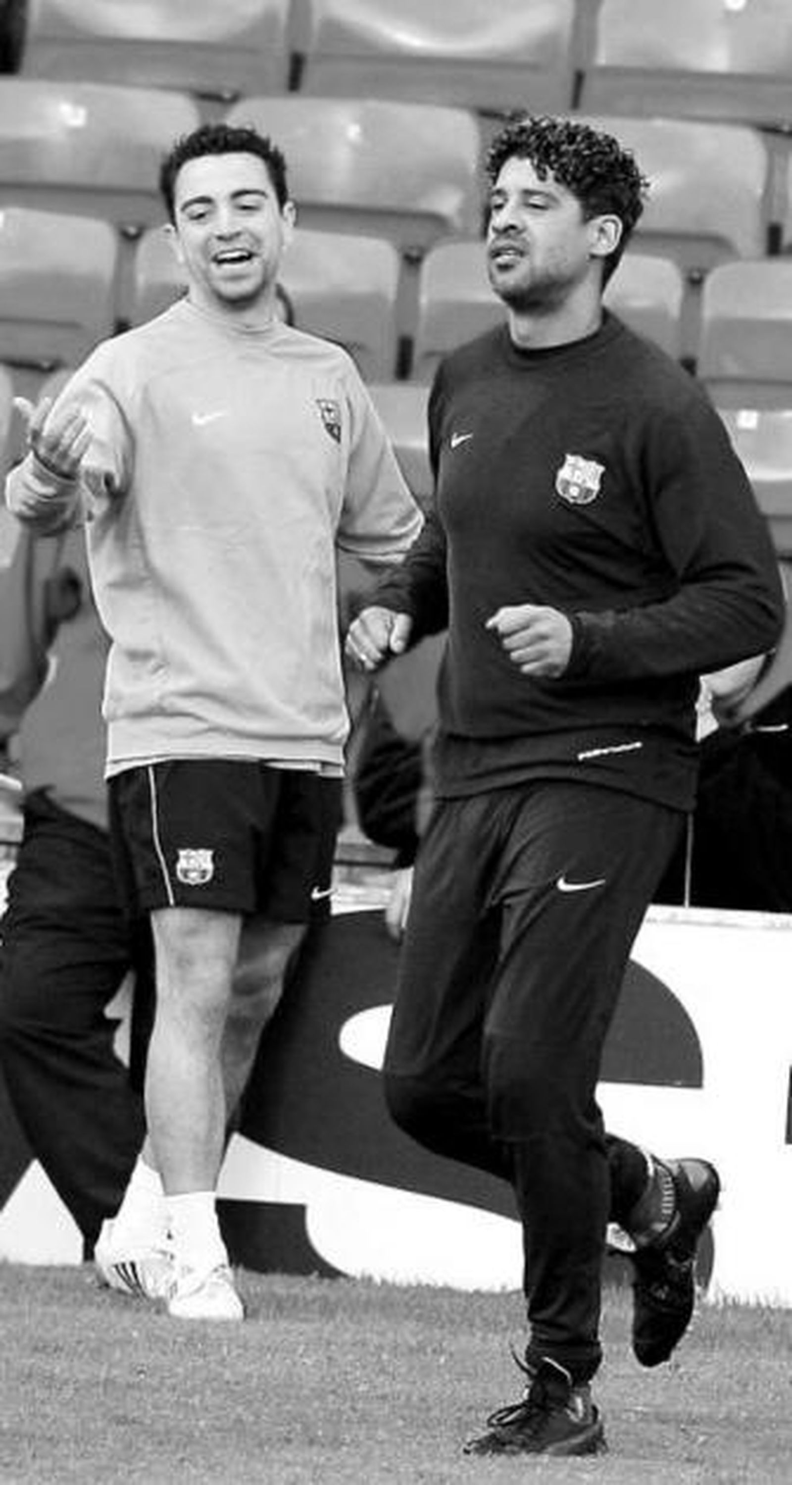 Xavi sonríe durante el entrenamiento junto a Rijkaard.