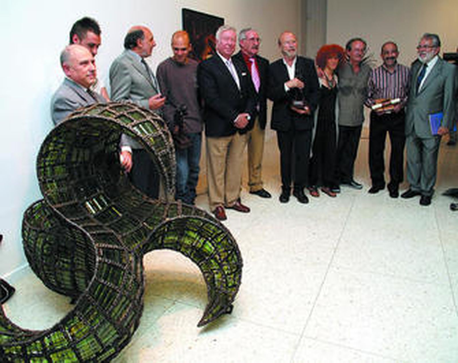 Guillermo Summers junto a las obras que expone.