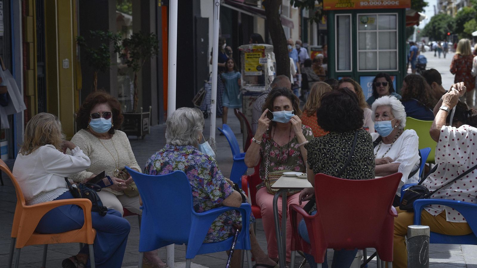 Varias mujeres se protegen con mascarilla en la terraza de un bar.
