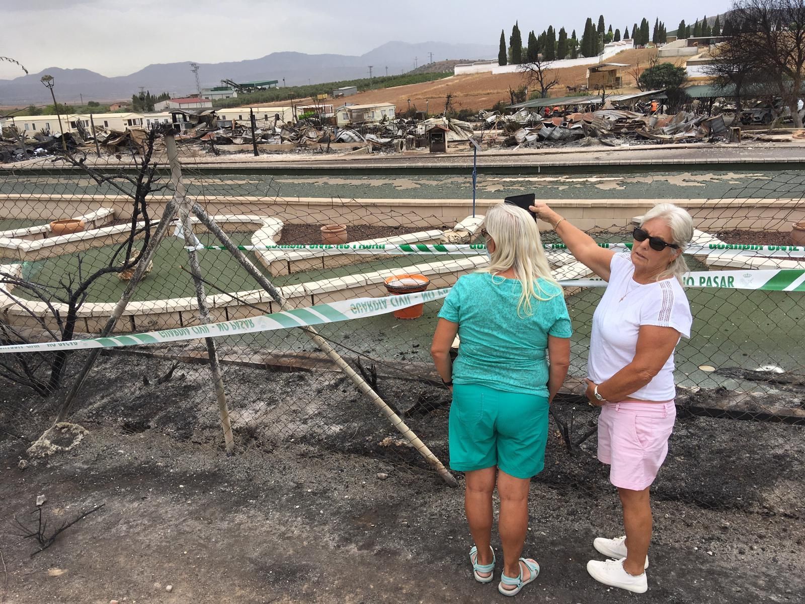 Dos mujeres contemplan el estado del camping de Mollina tras el incendio.
