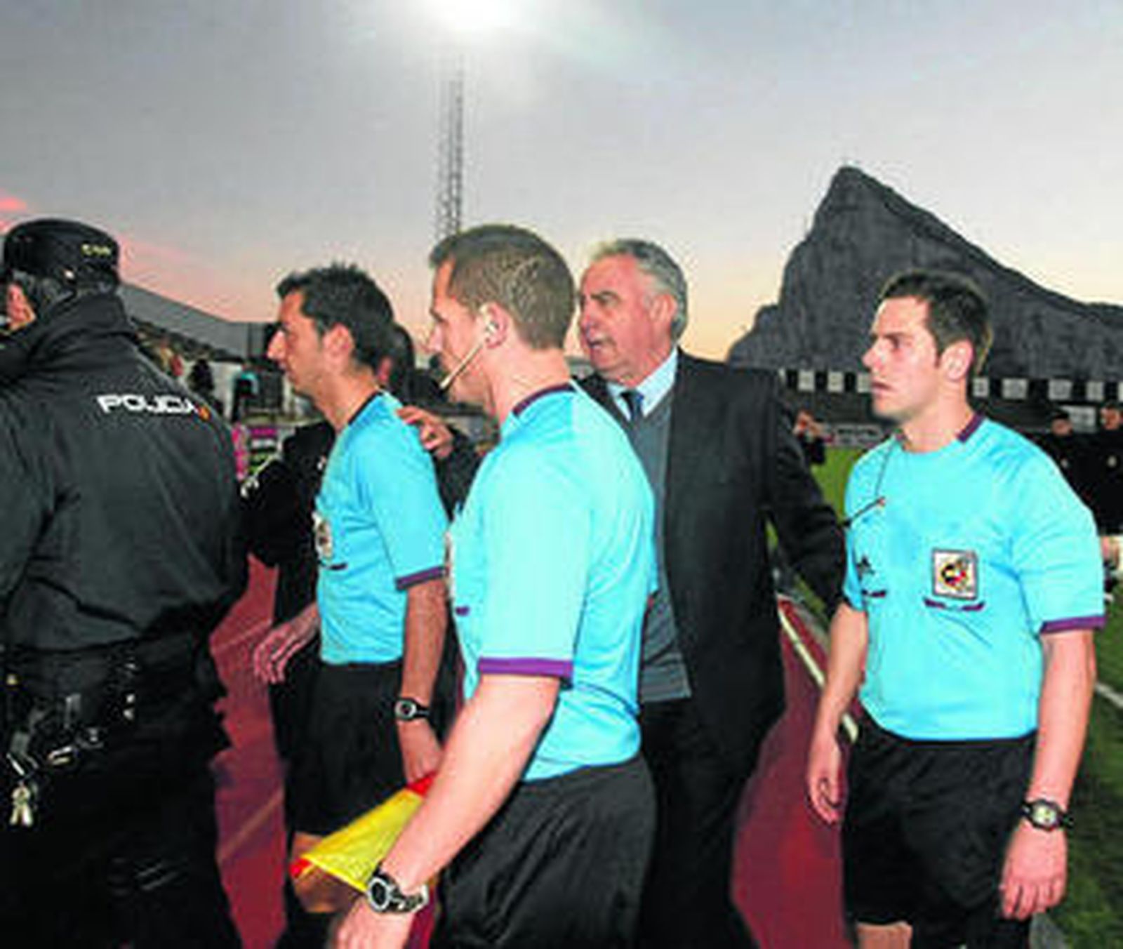 El presidente acompaña al trío arbitral hacia los vestuarios.