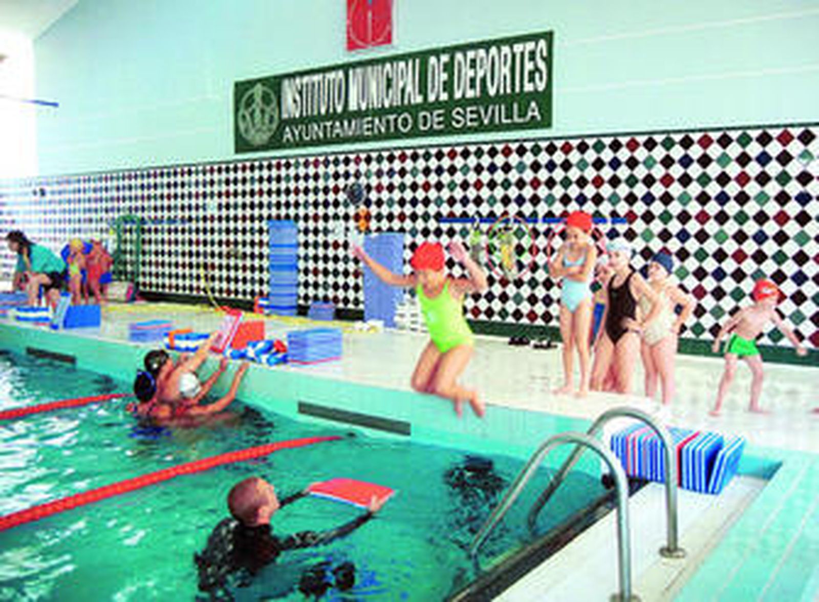 Unos niños aprenden a nadar en la Piscina Municipal Virgen de los Reyes, en una imagen de otra temporada.