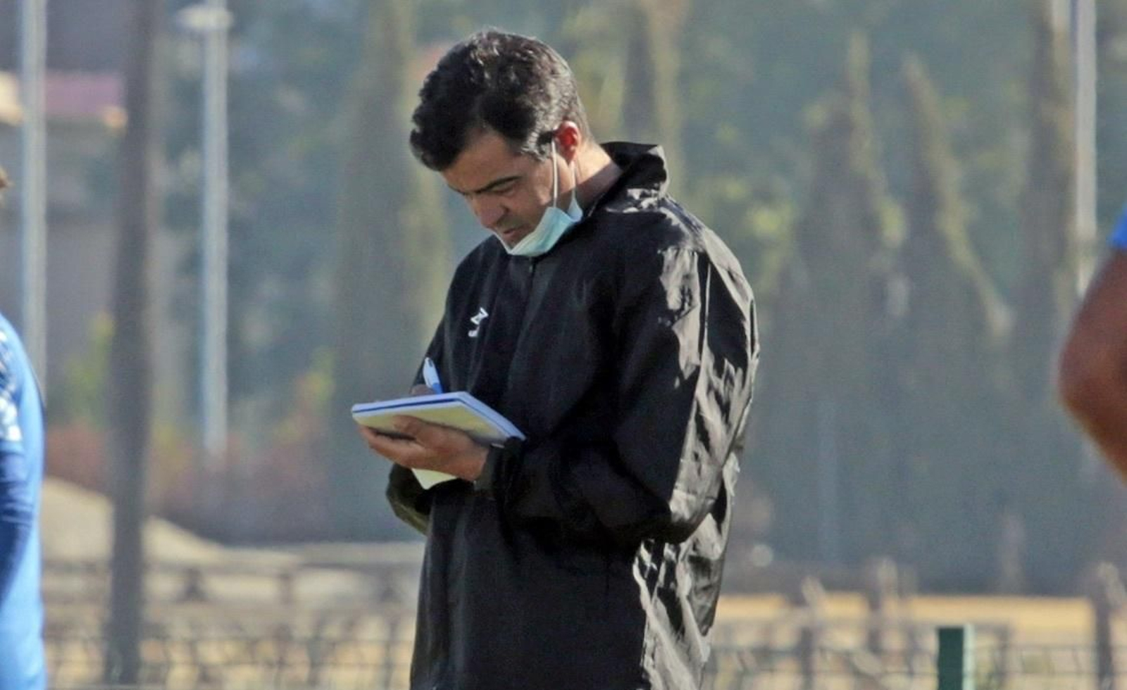 José Pérez Herrera toma notas en una libreta durante un entrenamiento.